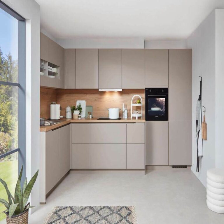 Musterküche in Kaschmir Musterküche in Kaschmir als L-Küche mit Holzrückwand und Backofen im Hochschrank – Küchenaufbau Erlangen